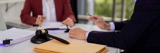 Business professionals discuss a legal matter at a conference table with contracts and a gavel, representing a New York tortious interference dispute.