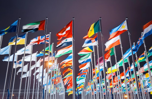 Flags from different nations representing the many countries where international employers may have employees. International employers may want to consult with a lawyer to better understand wage and hour laws.