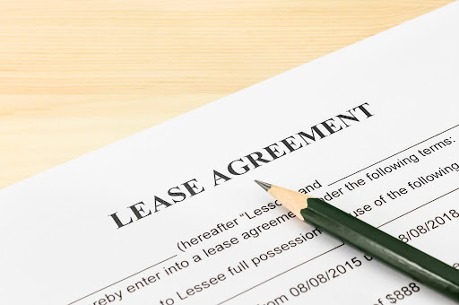 Image of a sample Lease Agreement with a pencil; carefully reviewing lease agreements can prevent property disputes.