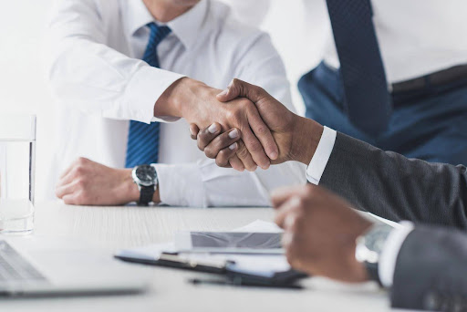 Two businesspeople shaking hands; mediation and arbitration can be an effective method of avoiding business lawsuits.
