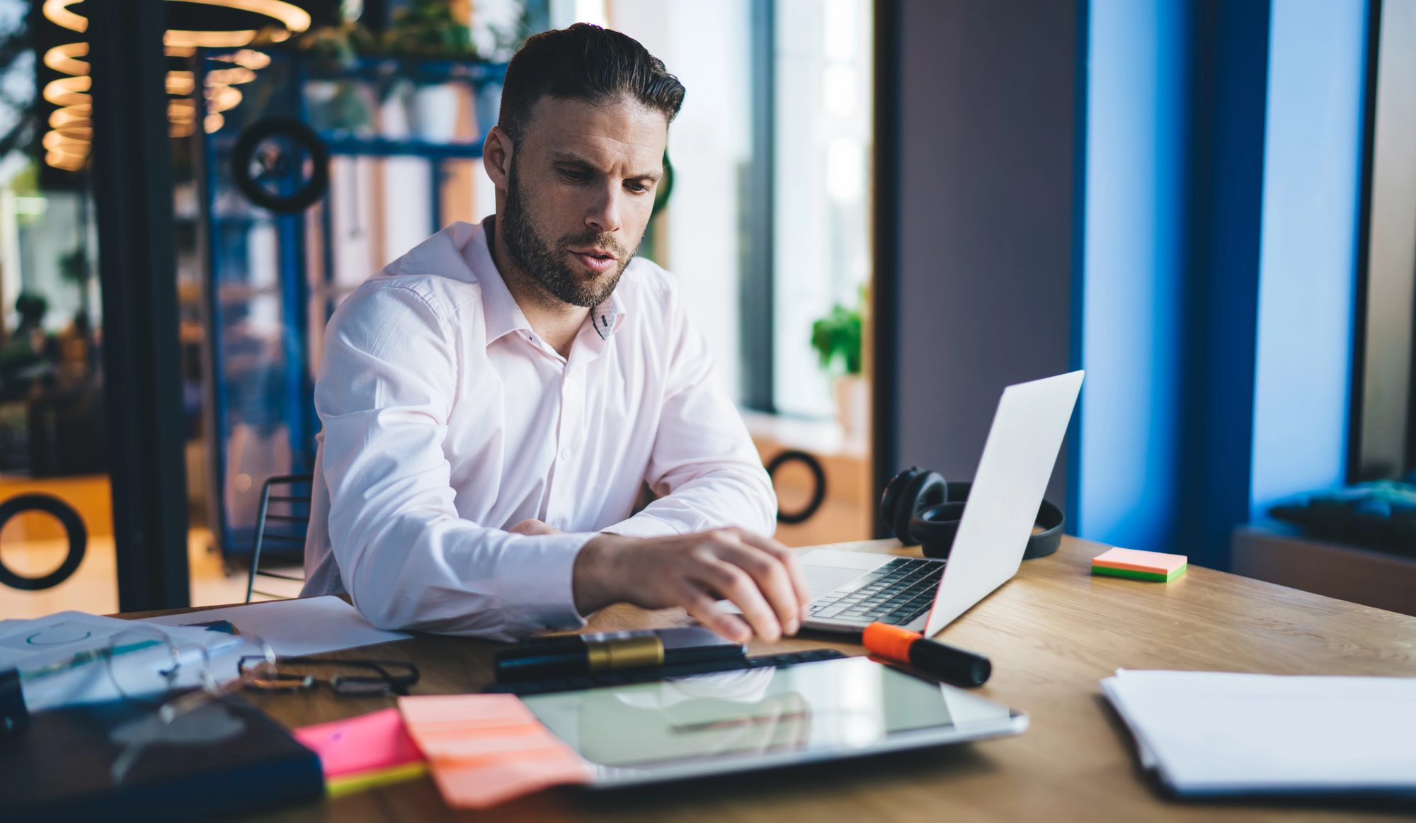 A man does remote work from a home office; workers’ compensation claims for remote employees may require unique legal solutions.