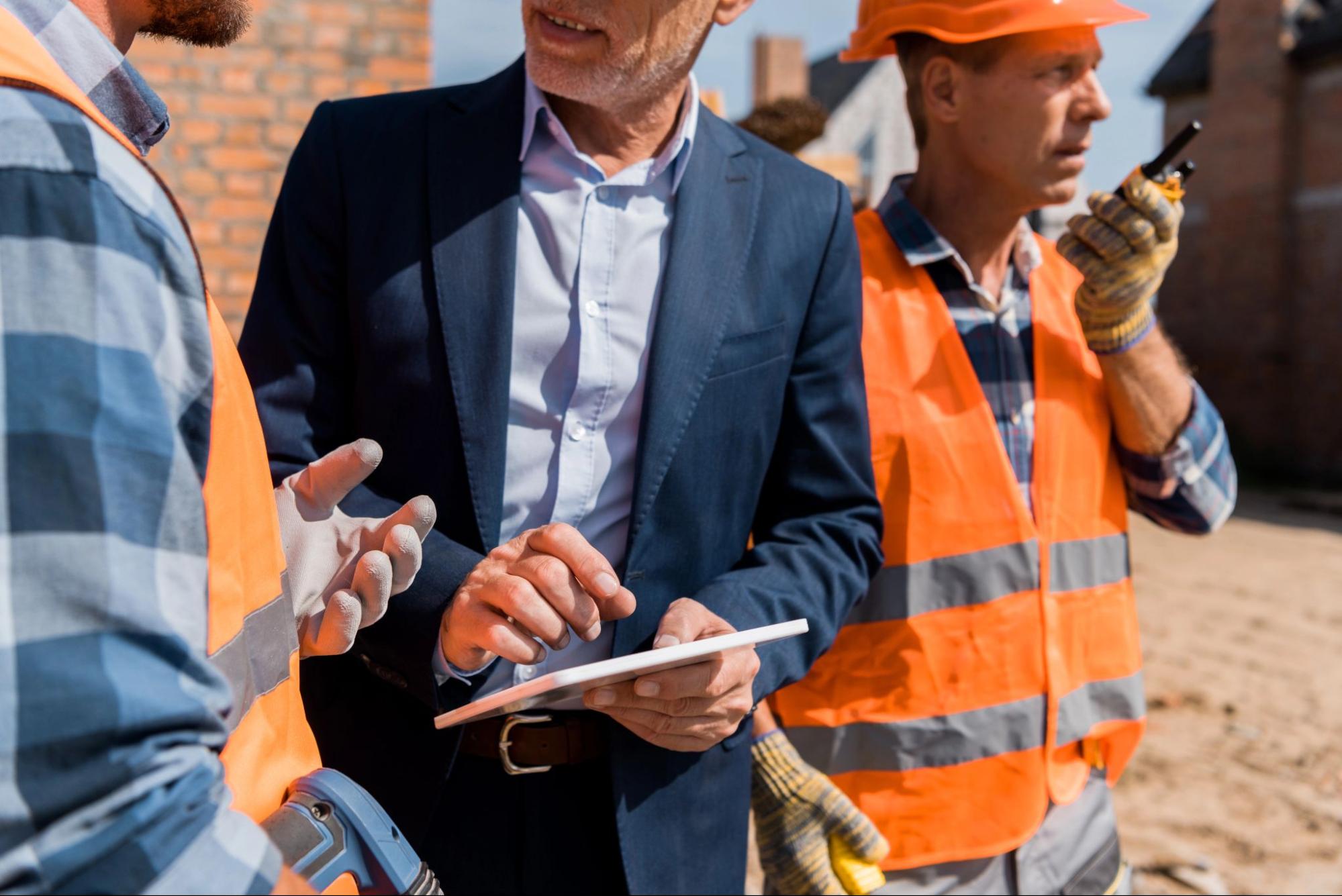 A business owner mulls over his risk management parameters while discussing workers’s comp with an employee.