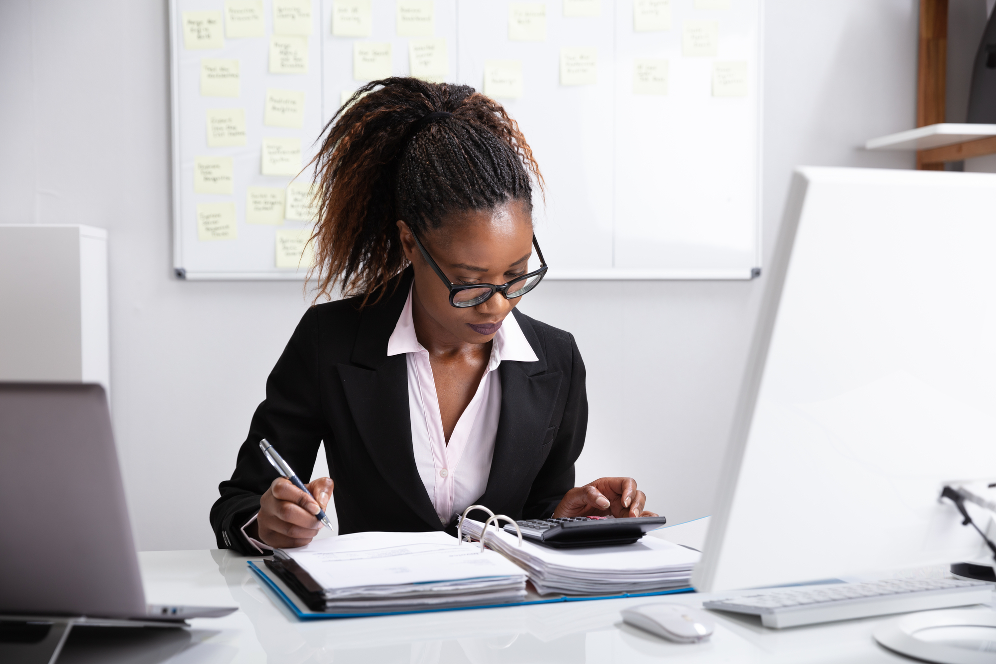 A woman in a suit conducting workers’ compensation audits on a company.